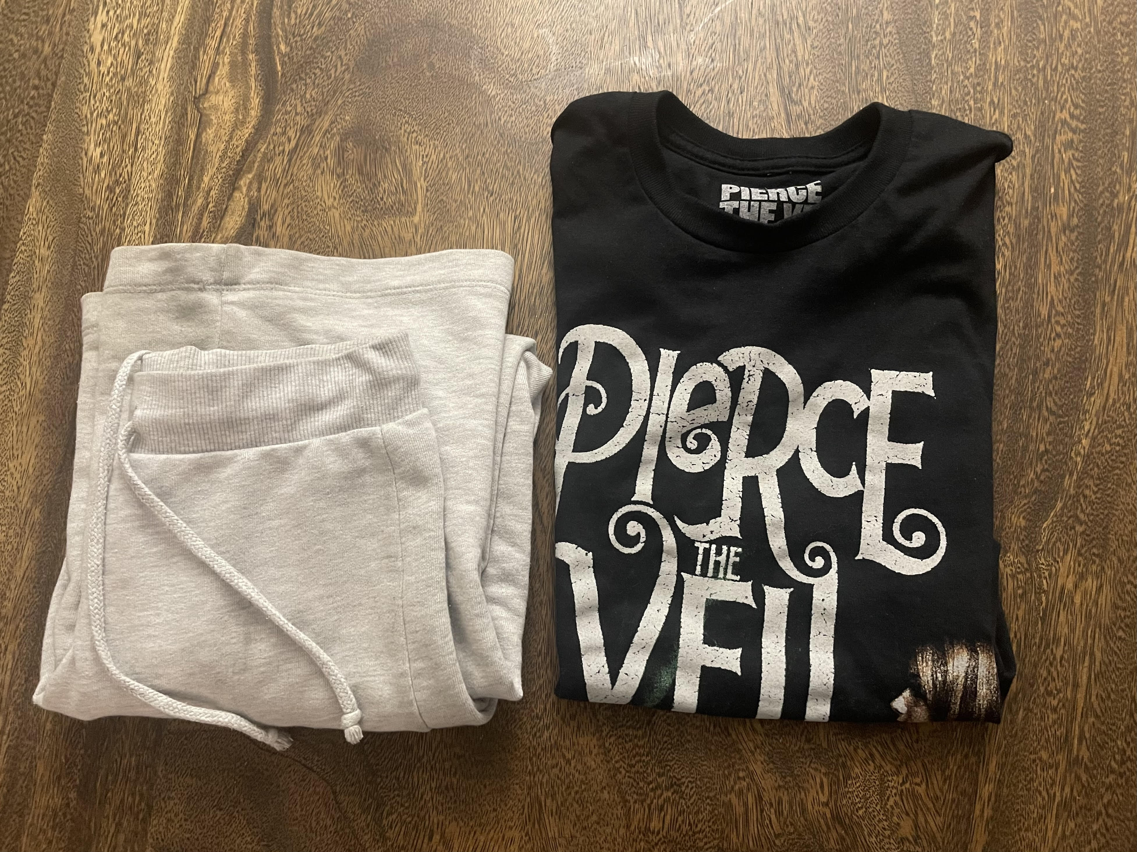 A Pierce the Veil band tee with sweatpants next to it.